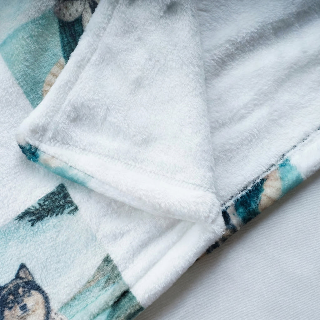 Folded robe material with a pattern of cats on a white background. The material is flannel. 